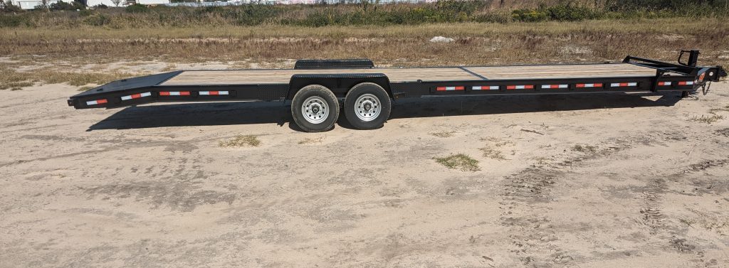 Down 2 Earth 82 inch x 34 foot car hauler trailer with dual 7,000 lb axles, slide-in ramps, treated 2x8 wood deck, D-ring tie downs, and LED lighting